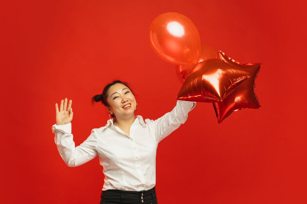 美丽红墙上拿着气球的亚洲年轻女子灯笼中国女性