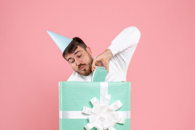 前面正面图：年轻男性站在礼物盒内 穿着粉色睡衣 参加派对 激情睡眠 圣诞快乐颜色成人聚会