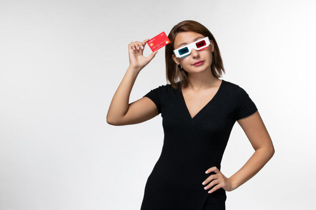 电影院正面图年轻女性手持红色银行卡 戴着d型太阳镜 表面呈浅白色电影浅白色太阳镜