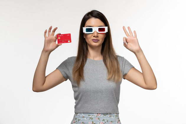 前面正面图：戴着d型太阳镜手持银行卡的年轻女性 浅白色表面太阳镜性感孤独