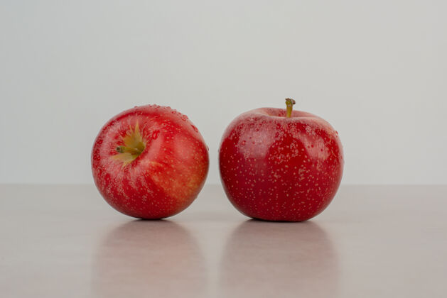 红色大理石桌上有两个红苹果水果苹果美味