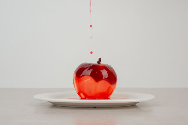 红色在白盘子里用糖浆浇苹果水果食物苹果