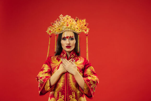 穿着中国传统的优雅女子在红墙工作室节日文化服饰