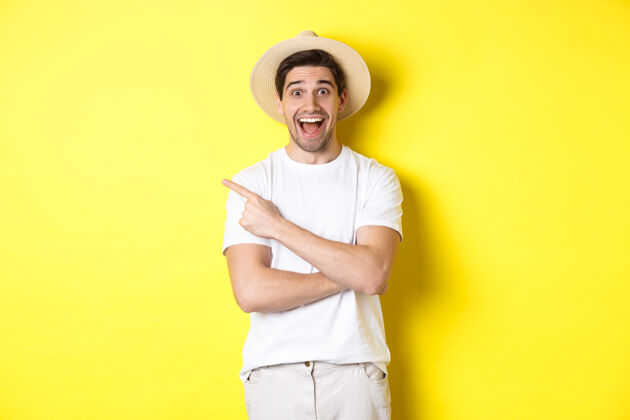 帅哥旅游理念和生活方式快乐的年轻男性游客展示广告 左手指指点点 微笑兴奋 黄色背景节日秀时尚