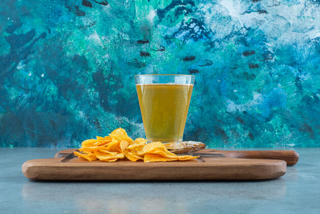 美味薯条 鱼和一杯啤酒放在木板上 大理石背景上玻璃美味垃圾