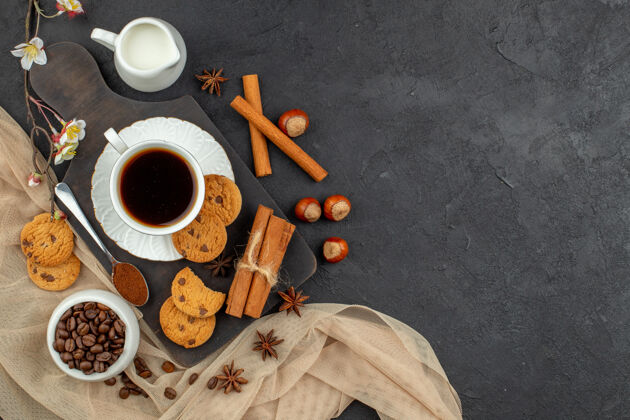 饮料顶视图一杯咖啡茴香饼干勺子放在木板上咖啡豆放在碗里黑暗的表面上碗杯子早餐