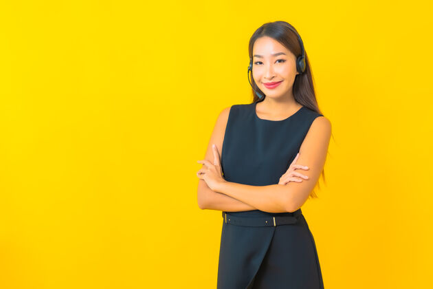 工人肖像美丽的年轻亚洲女商人与耳机呼叫中心客户关怀黄色背景助理代理服务