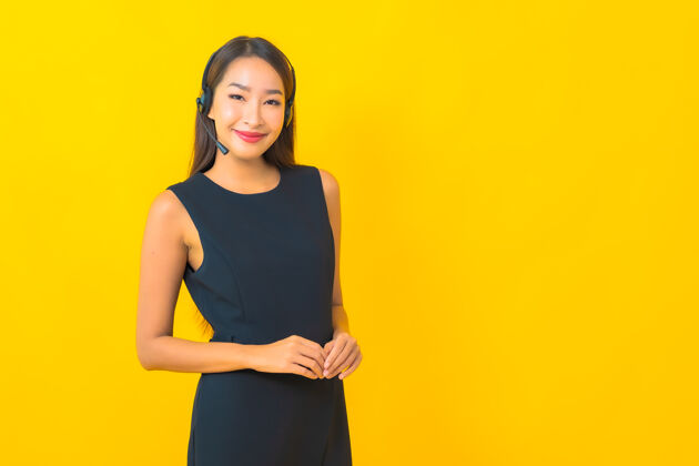 支持肖像美丽的年轻亚洲女商人与耳机呼叫中心客户关怀黄色背景代理护理电话