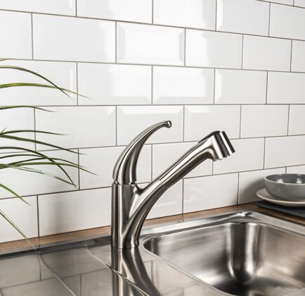 现代的新的和现代的钢水龙头在厨房里家庭水槽洗涤
