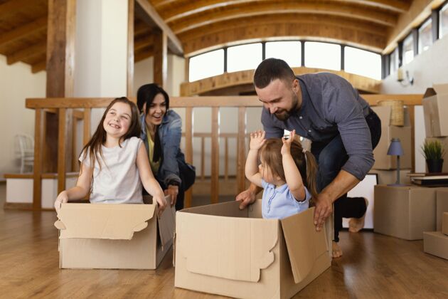 房子全镜头的孩子和父母一起玩搬家盒子家庭