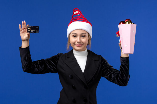 工人前视图年轻女士拿着银行卡在蓝墙新年情感假期玩具观点工作人