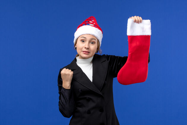 人正面图：年轻女子手持红色圣诞袜在蓝色办公桌上过年过节工程师前面袜子