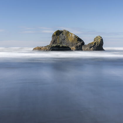 海滩一个巨大的岩石与海洋的迷人镜头清洁反射巨大