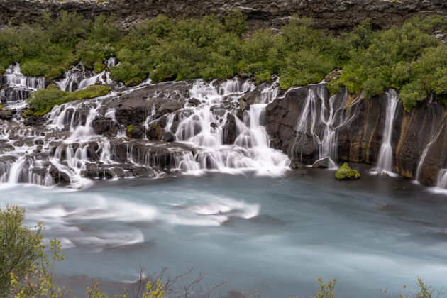 岩石冰岛白天 绿色植物环绕着赫兰福萨瀑布春天水冰岛