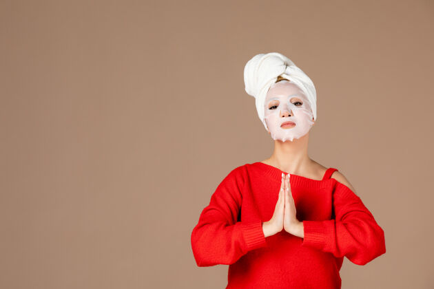 淋浴正面图粉色背景上戴着面具的年轻女性护肤风景润肤霜