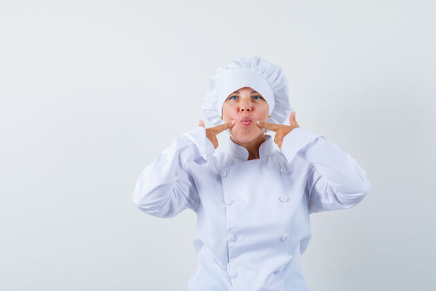好看一位身穿白色制服的女厨师用手指按压脸颊 看上去很滑稽女士脸颊漂亮