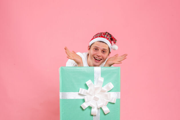 脸正面图：穿着白色衬衫的年轻男性 粉色背景的礼物正面风景圣诞
