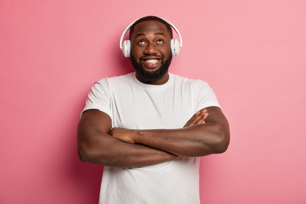 播放列表美国黑人男子双臂合十 抬头仰望 佩戴立体声配件听音乐 欣赏播放列表中最喜爱的歌曲 在室内娱乐听力耳机年轻