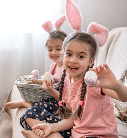 孩子们带着兔子耳朵的小姐妹们摆出复活节彩蛋的姿势摆姿势复活节准备