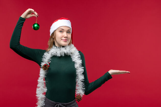 帽子前视图年轻女性在红色背景上摆出新年的姿势服装圣诞节姿势