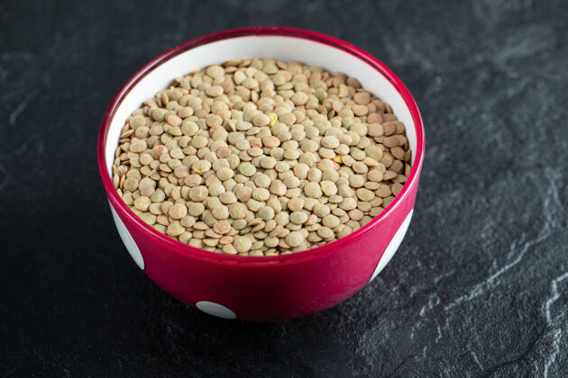 干燥一个红色的碗 上面放着干的棕色生小扁豆健康豆类豆类
