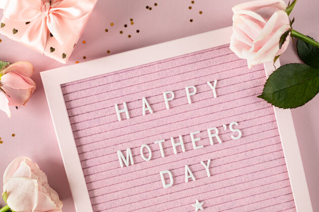 记忆粉色毡信纸上写着“母亲节快乐”的字样粉色表面印有玫瑰和礼物盒的喜庆构图俯视图 平面图复印空间组成粉彩文字