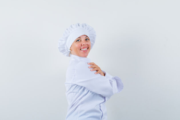 年轻身穿白色制服的女厨师交叉双臂站着 看上去很高兴女人卷发模特