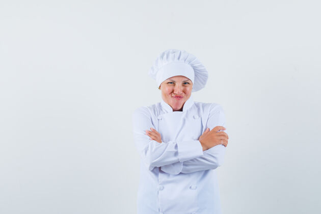 化妆品身着白色制服的女厨师交叉着双臂摆姿势 看上去很快乐人欢乐交叉
