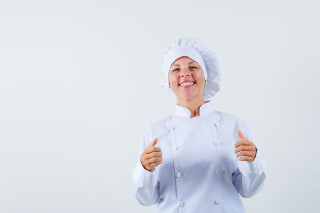 人穿着白色制服的女厨师竖起大拇指 看上去很高兴乐趣肖像女性