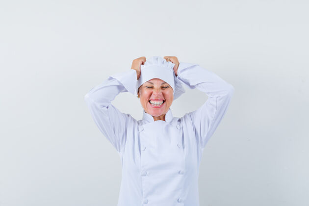 女人穿着白色制服的女厨师手举在头上 看起来很幸运眼睛时尚脸
