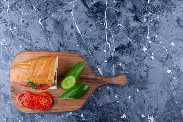 面包三明治 黄瓜片和西红柿放在蓝色的砧板上美味烘焙风味