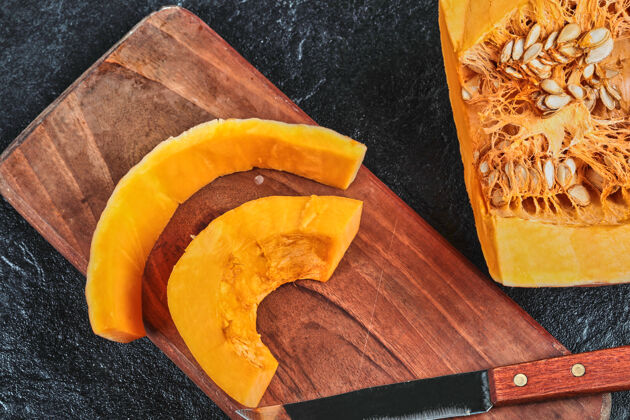 切割用刀把南瓜片放在木砧板上背景桌子水果