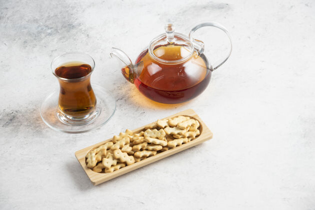 丰盛一个装着一杯茶和一块装满饼干的木板的玻璃茶壶饮料可食用美味