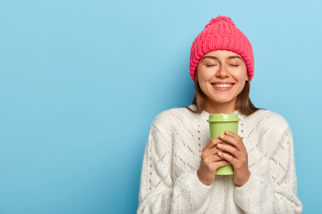 肖像满意的欧洲女人横拍用热饮放松 拿着外卖咖啡 愉快地微笑人毛衣冬天