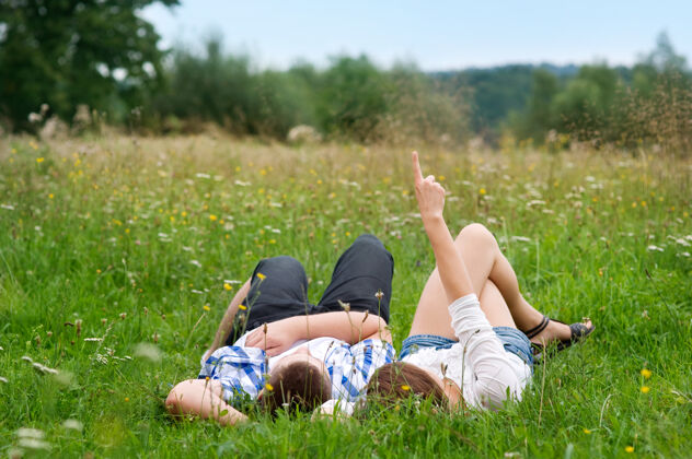 人类繁衍一对躺在草地上的夫妇年轻人观看户外