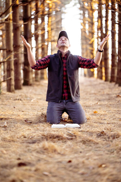人一个男人在森林里祈祷的垂直选择性聚焦镜头男性徒选择