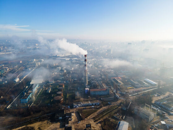 塔无人机俯瞰基希讷乌热电站 烟囱冒出浓烟建筑物和道路空气中有雾摩尔多瓦首都世代上升