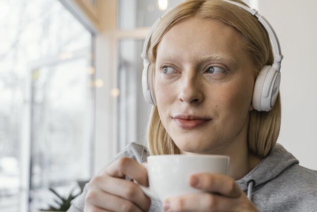 年轻人特写戴耳机的女人多样性休闲设备