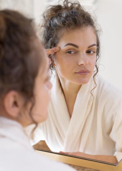 面部护理照镜子做美容的女人模特浴袍镜子