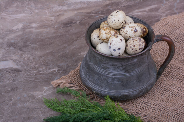 产品鹌鹑蛋放在一个金属锅里 里面有香草餐具餐厅菜单