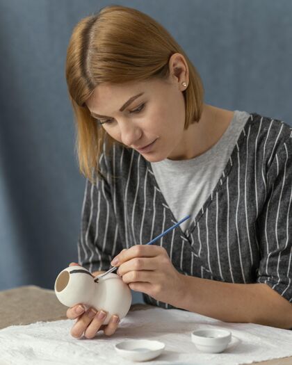 爱好中等身材的女人用画笔画画女人室内手工