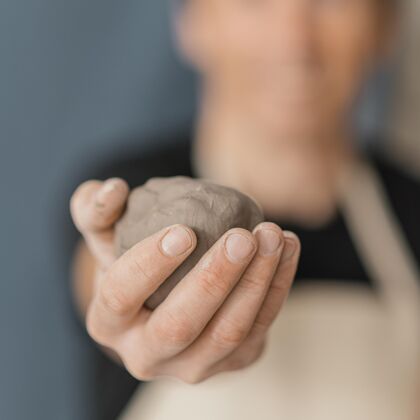 手工特写模糊的人拿着粘土里面陶器手工制作