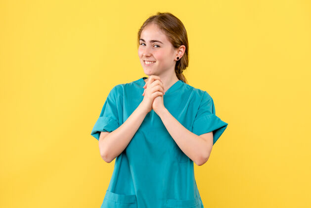 漂亮正面图黄色背景上微笑的女医生保健院感慨工作医院站着