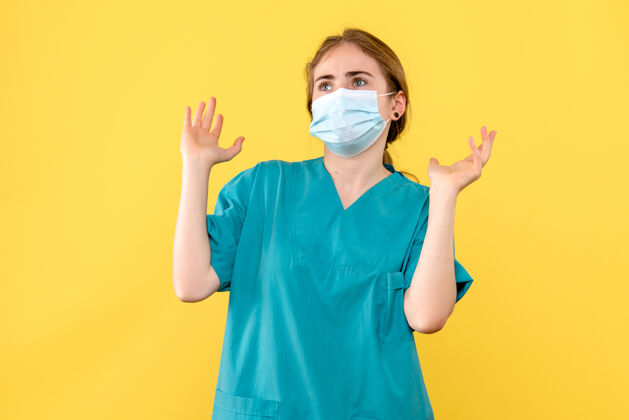 肖像正面图黄色背景上戴面罩的女医生-医院大流行医疗男性封面