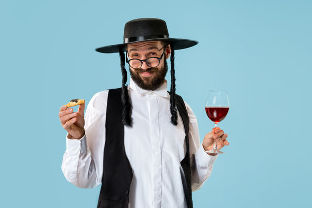 吃年轻的东正教犹太男子拿着哈曼塔森饼干庆祝普赖姆节光明节男人文化