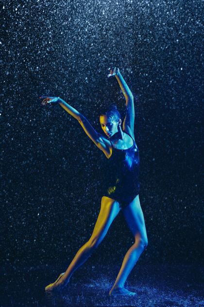 身体年轻的女芭蕾舞演员在水滴和浪花下表演白种人模特在霓虹灯下跳舞迷人的女人芭蕾舞和当代舞蹈概念明亮年轻运动