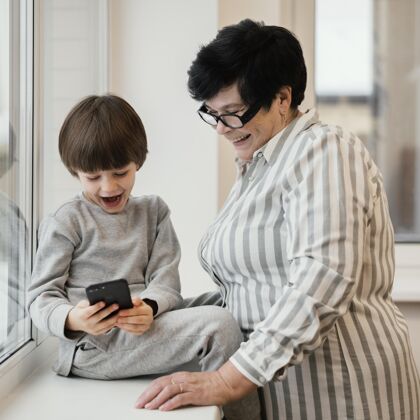 祖母笑笑奶奶看孙子玩智能手机邦德团结女人