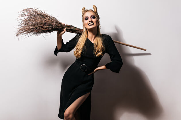 魔术师身材匀称的吸血鬼女扮黑妆万圣节派对上漂亮的巫婆拿着扫帚魔鬼恐怖漂亮