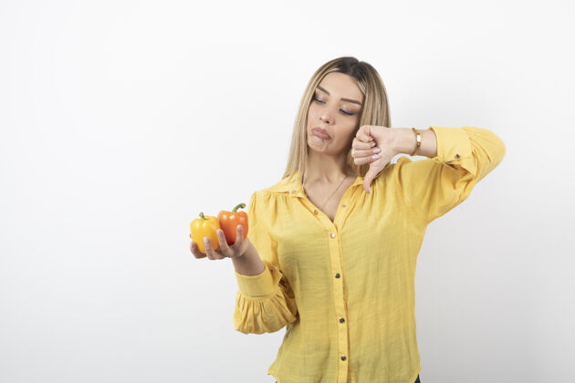 随意一幅金发女人拿着五颜六色的甜椒 竖起大拇指的画像情感女人站着