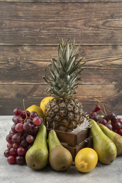 葡萄成熟的菠萝装在木箱里 大理石表面有各种新鲜水果食用梨有机